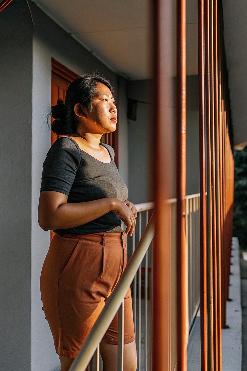 a Vietnamese American woman in her early forties on a balcony at golden hour
